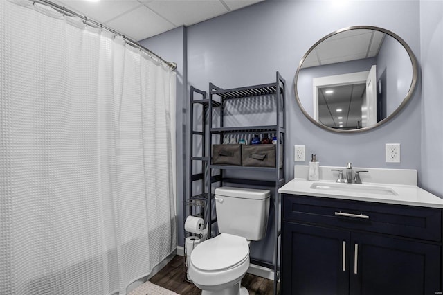 bathroom featuring vanity, a shower with curtain, wood finished floors, a drop ceiling, and toilet