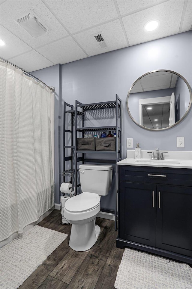 bathroom with visible vents, toilet, a paneled ceiling, and wood finished floors