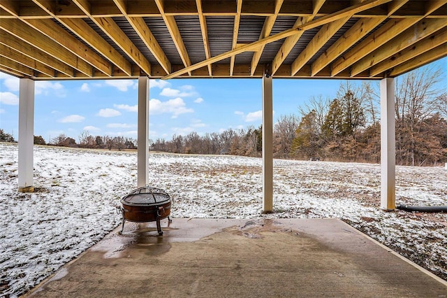 snow covered patio featuring a fire pit