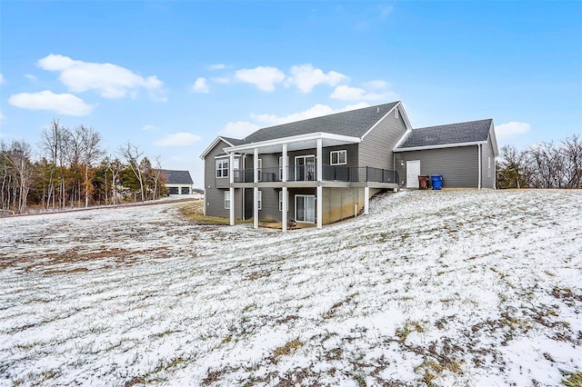 snow covered house featuring a wooden deck