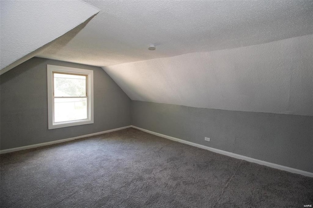 bonus room with baseboards, a textured ceiling, carpet, and vaulted ceiling