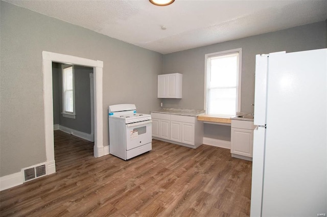 kitchen featuring light wood-style flooring, white appliances, white cabinetry, and baseboards