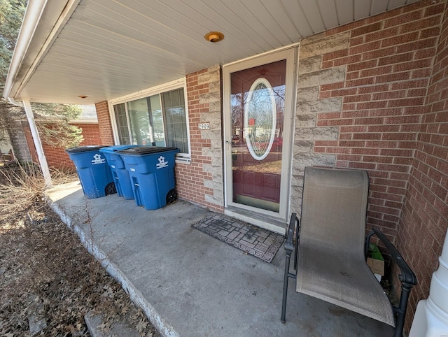 property entrance featuring brick siding and covered porch