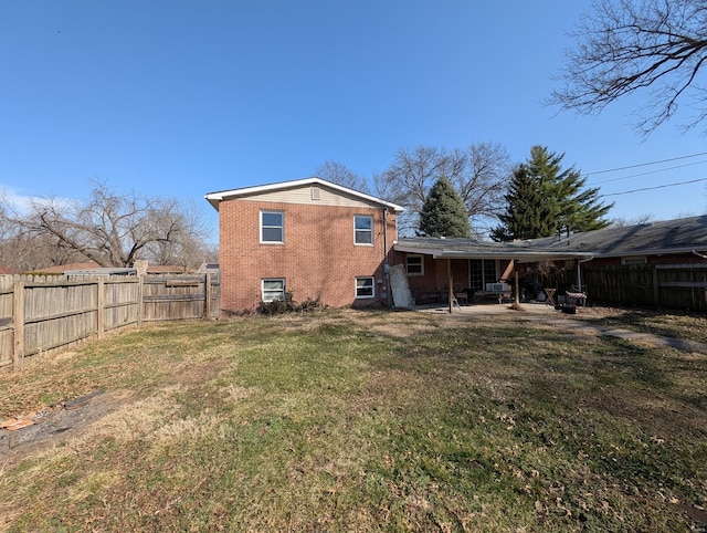 back of property featuring a fenced backyard, a patio, brick siding, and a yard