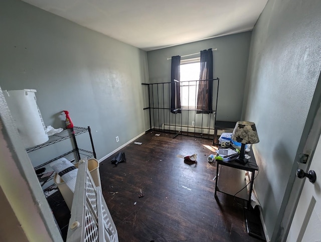 interior space featuring wood finished floors, baseboards, and a baseboard radiator