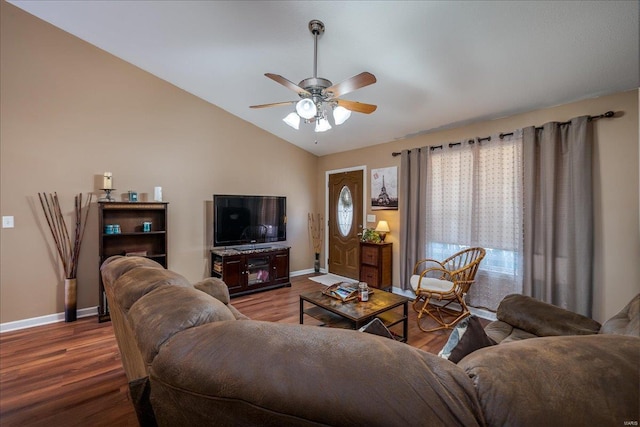 living area with baseboards, lofted ceiling, wood finished floors, and a ceiling fan