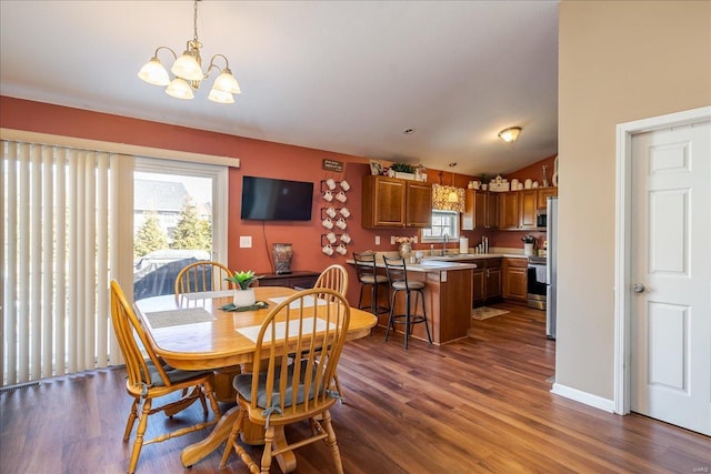 dining room featuring a notable chandelier, baseboards, and dark wood-style flooring