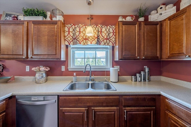 kitchen featuring dishwasher, light countertops, decorative light fixtures, and a sink