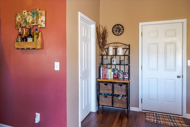 foyer entrance with dark wood-style floors and baseboards