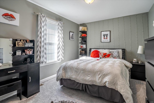 bedroom with wooden walls, multiple windows, baseboards, and carpet floors