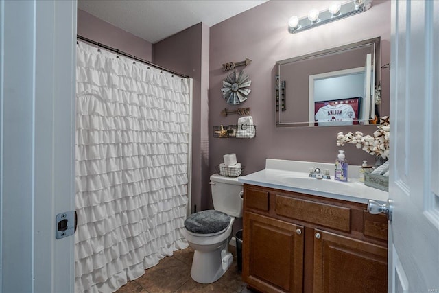 bathroom with toilet, vanity, and tile patterned flooring