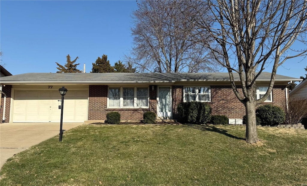 ranch-style home featuring a front lawn, an attached garage, brick siding, and driveway