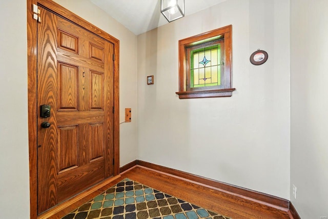 entryway with baseboards and dark wood-style floors