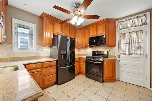 kitchen with light tile patterned floors, ceiling fan, brown cabinetry, tasteful backsplash, and black appliances