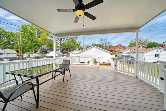 wooden terrace with a residential view, a ceiling fan, outdoor dining space, and fence