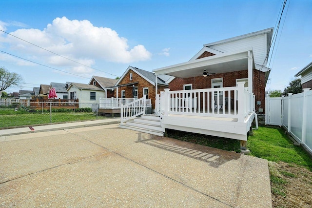 bungalow-style house with brick siding, ceiling fan, and fence