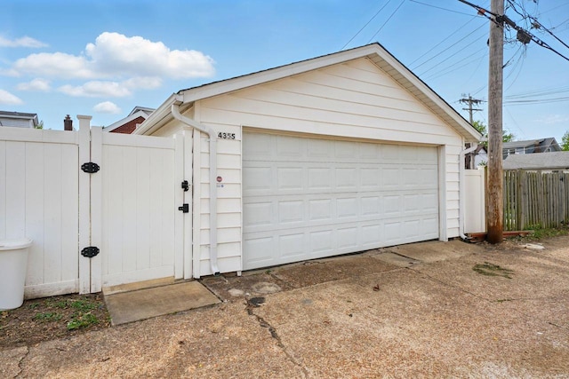 detached garage with a gate and fence