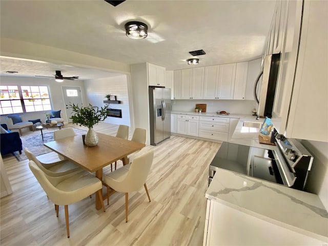 dining space with light wood-type flooring and ceiling fan