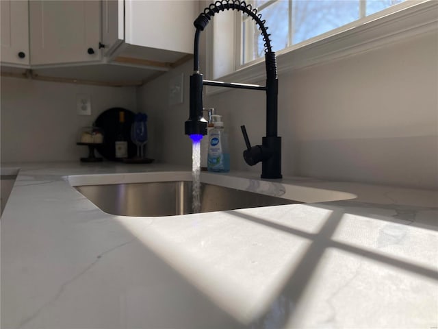 room details featuring white cabinets and a sink