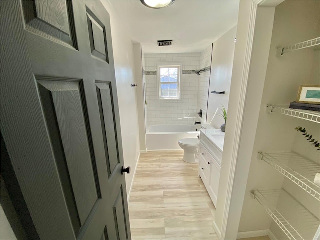 bathroom with vanity, wood finished floors, visible vents, shower / tub combination, and toilet