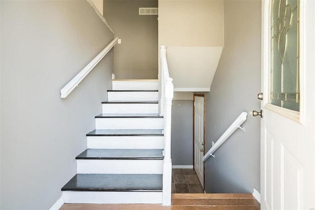 staircase with visible vents and baseboards