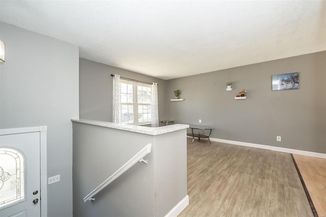 entryway with light wood-type flooring and baseboards