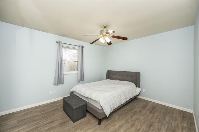 bedroom with ceiling fan, baseboards, and wood finished floors