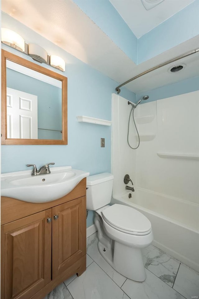 full bath with toilet, marble finish floor, vanity, and  shower combination