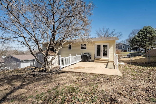 back of house with entry steps, a patio area, a shed, and fence private yard