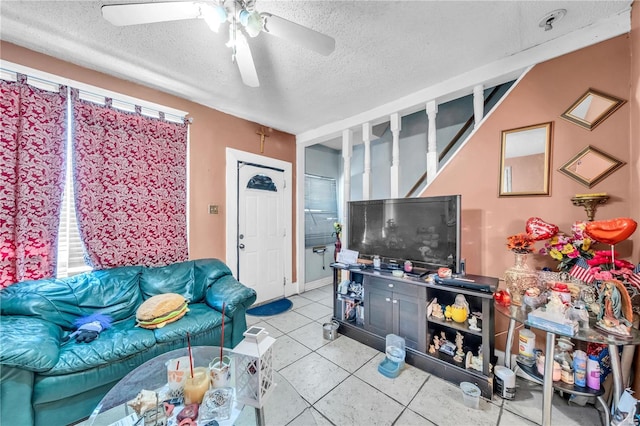 tiled living area with a textured ceiling and a ceiling fan