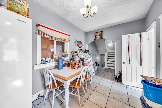 dining room with a notable chandelier, stairway, tile patterned floors, and a textured ceiling