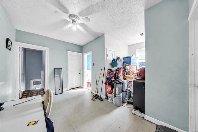 interior space with a textured ceiling, baseboards, and ceiling fan