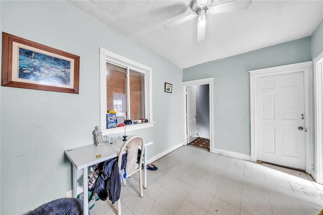 office area with a textured ceiling, baseboards, and ceiling fan