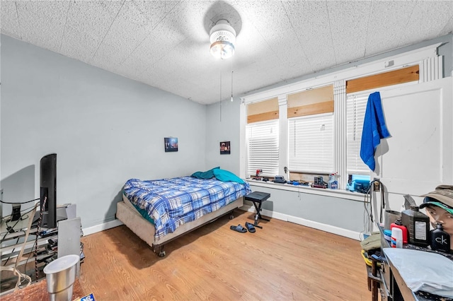 bedroom featuring baseboards and wood finished floors