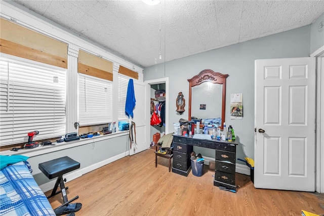 home office with baseboards and wood finished floors