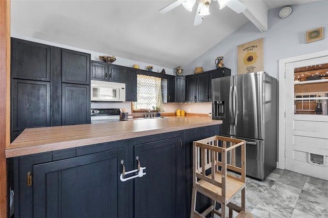 kitchen featuring stainless steel fridge, white microwave, stove, dark cabinets, and vaulted ceiling with beams