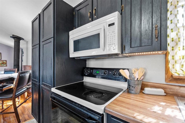 kitchen featuring range with electric stovetop, white microwave, and wood finished floors