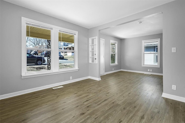 spare room featuring visible vents, wood finished floors, and baseboards