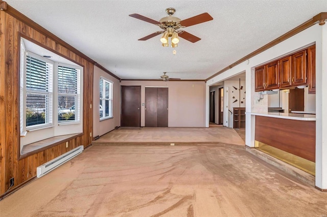 unfurnished living room with light carpet, baseboard heating, and crown molding