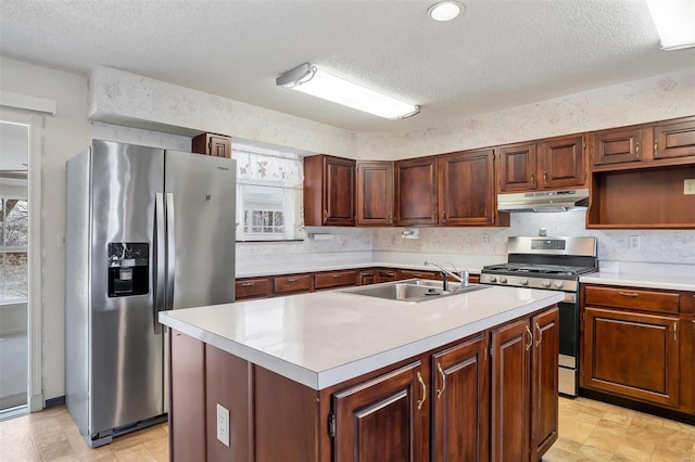 kitchen with under cabinet range hood, stainless steel appliances, light countertops, and a sink