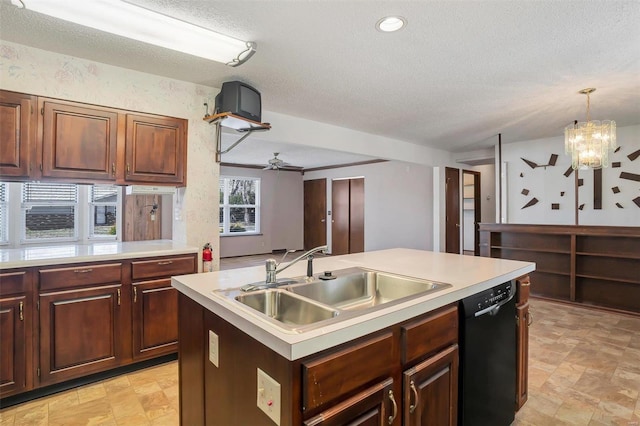 kitchen featuring a sink, light countertops, black dishwasher, ceiling fan with notable chandelier, and a kitchen island with sink