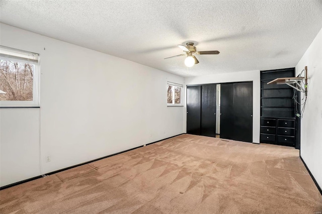 unfurnished bedroom featuring ceiling fan, a textured ceiling, and carpet