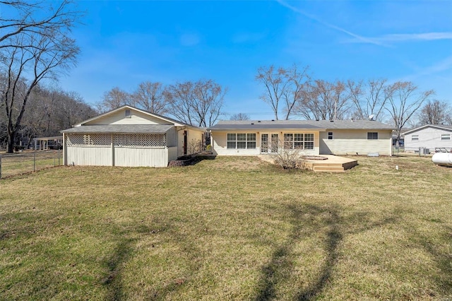 back of property with a lawn, french doors, and fence