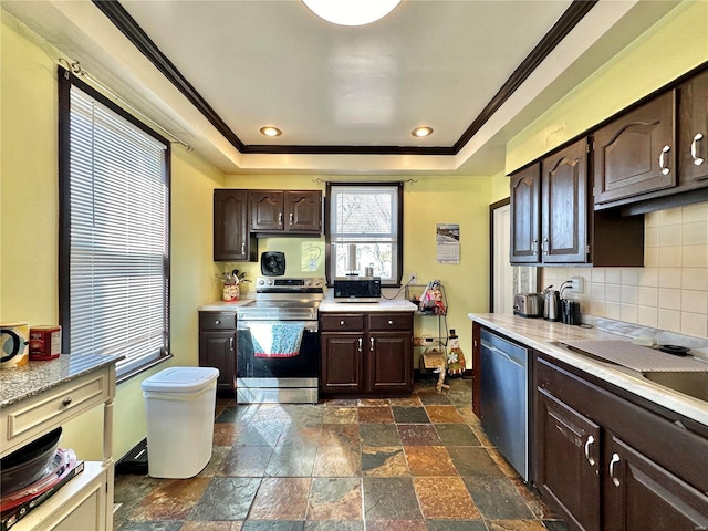 kitchen featuring stainless steel appliances, a raised ceiling, dark brown cabinetry, and light countertops