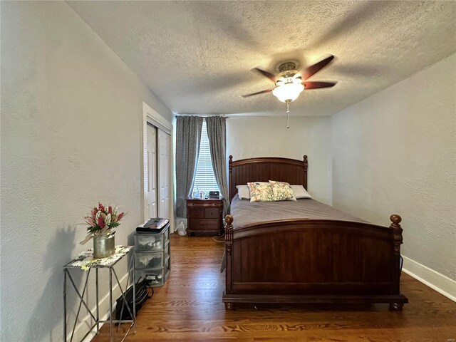 bedroom with baseboards, a textured ceiling, wood finished floors, and a textured wall