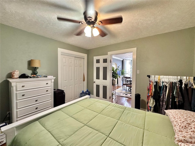 bedroom featuring ceiling fan, wood finished floors, a closet, and a textured ceiling