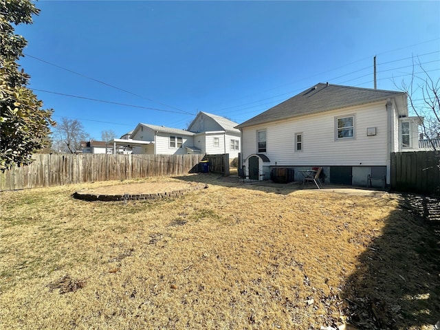 rear view of property with a lawn and fence