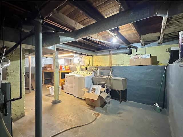 unfinished basement featuring a sink and washer and clothes dryer