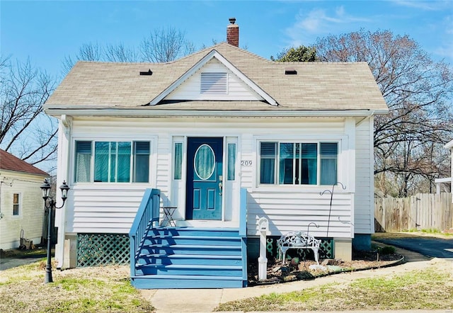 bungalow featuring fence and a chimney