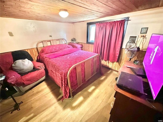 bedroom featuring wood finished floors, wooden walls, wood ceiling, and wainscoting